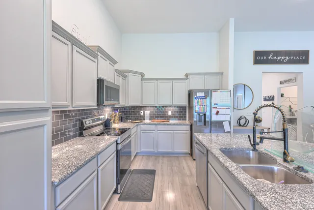 a kitchen with kitchen island granite countertop a sink stove and cabinets