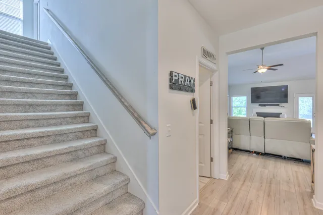 a view of a hallway with wooden floor and staircase