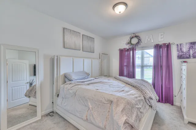 a bedroom with a large bed and a window