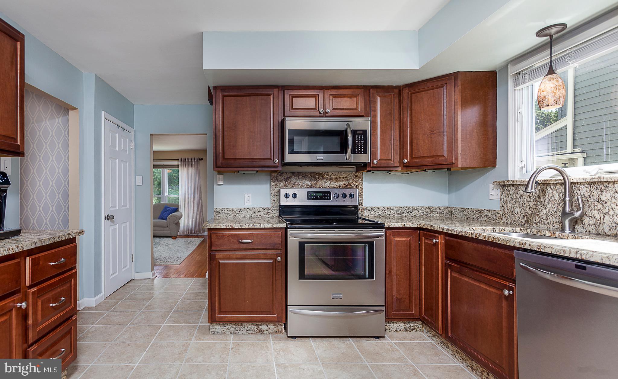 141 Lewis Road Havertown, PA 19083 - Photo 11 of 33 a kitchen with granite countertop a stove top oven microwave and cabinets