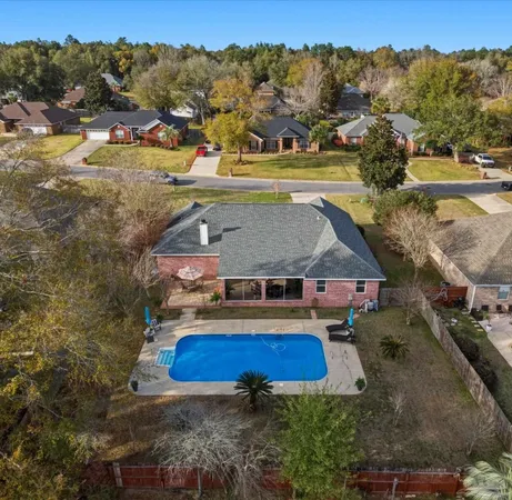 an aerial view of residential houses with outdoor space and swimming pool