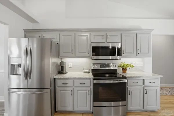 a kitchen with cabinets stainless steel appliances and a counter space