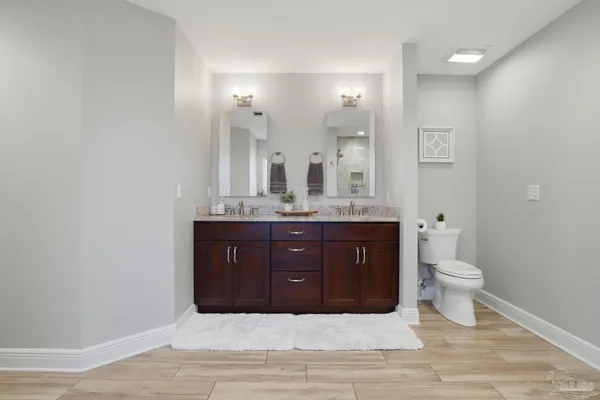 a bathroom with a granite countertop sink and a toilet