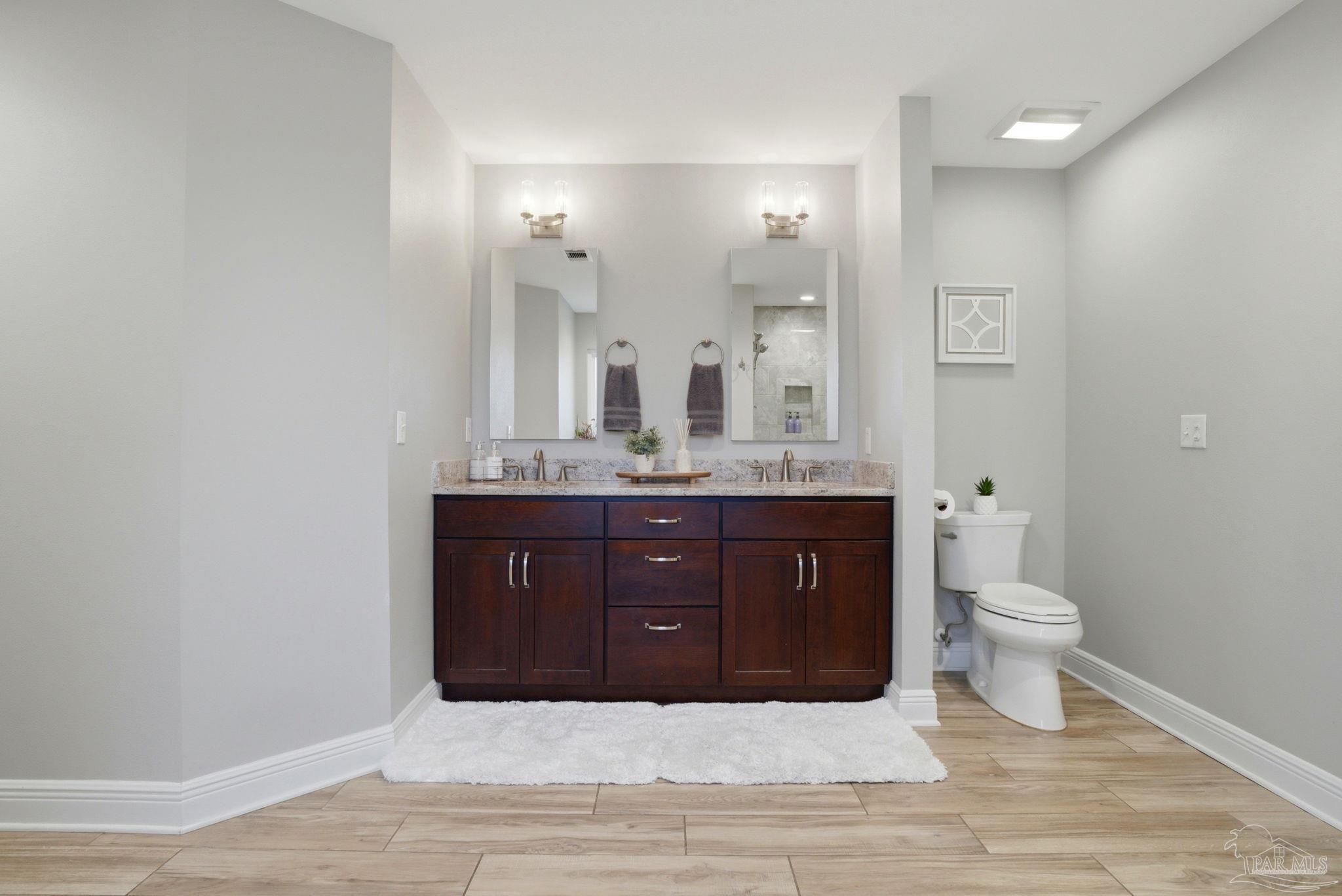 4249 Spindlewick Drive Pace, FL 32571 - Photo 15 of 26 a bathroom with a granite countertop sink and a toilet