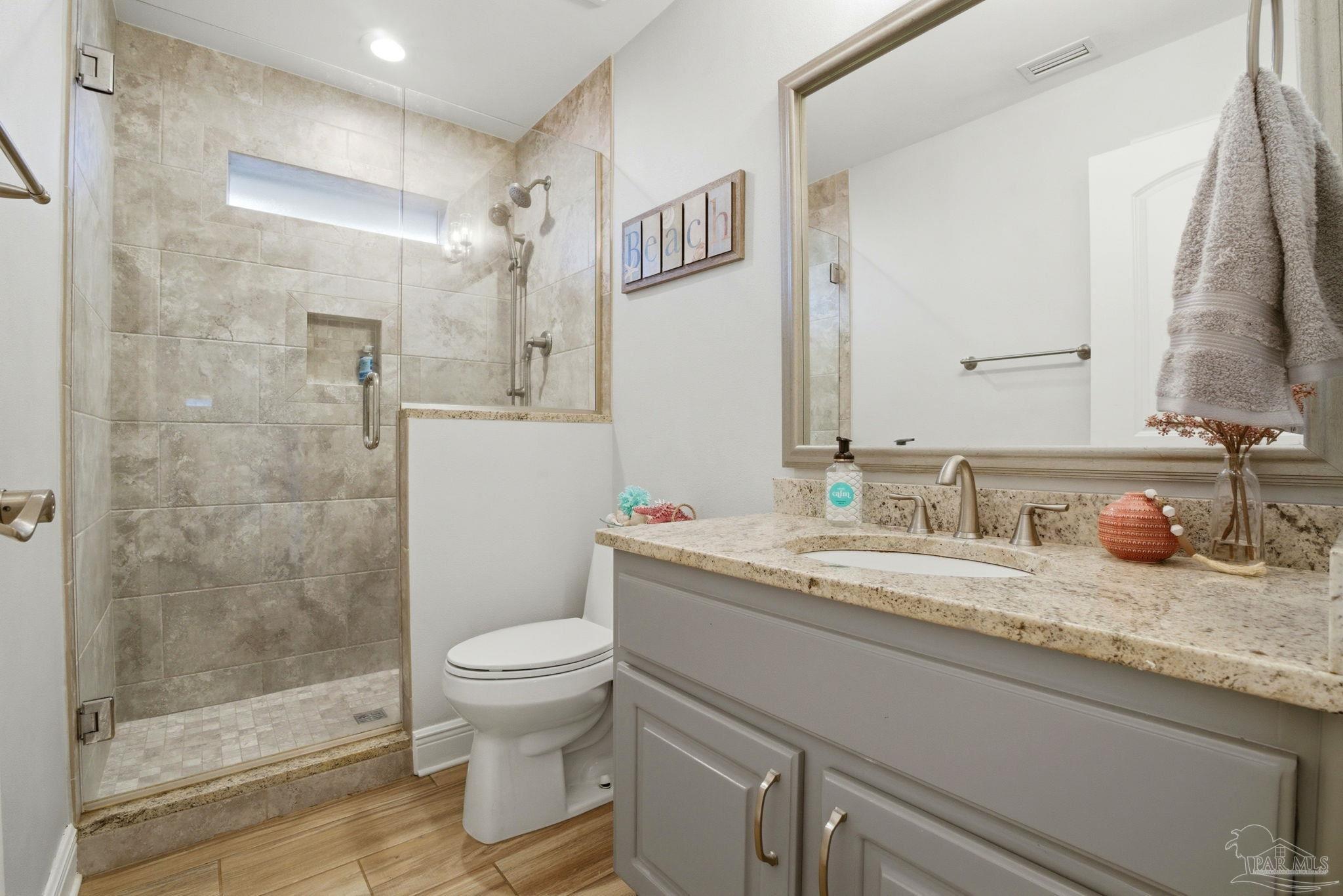 4249 Spindlewick Drive Pace, FL 32571 - Photo 20 of 26 a bathroom with a granite countertop sink a toilet and a mirror