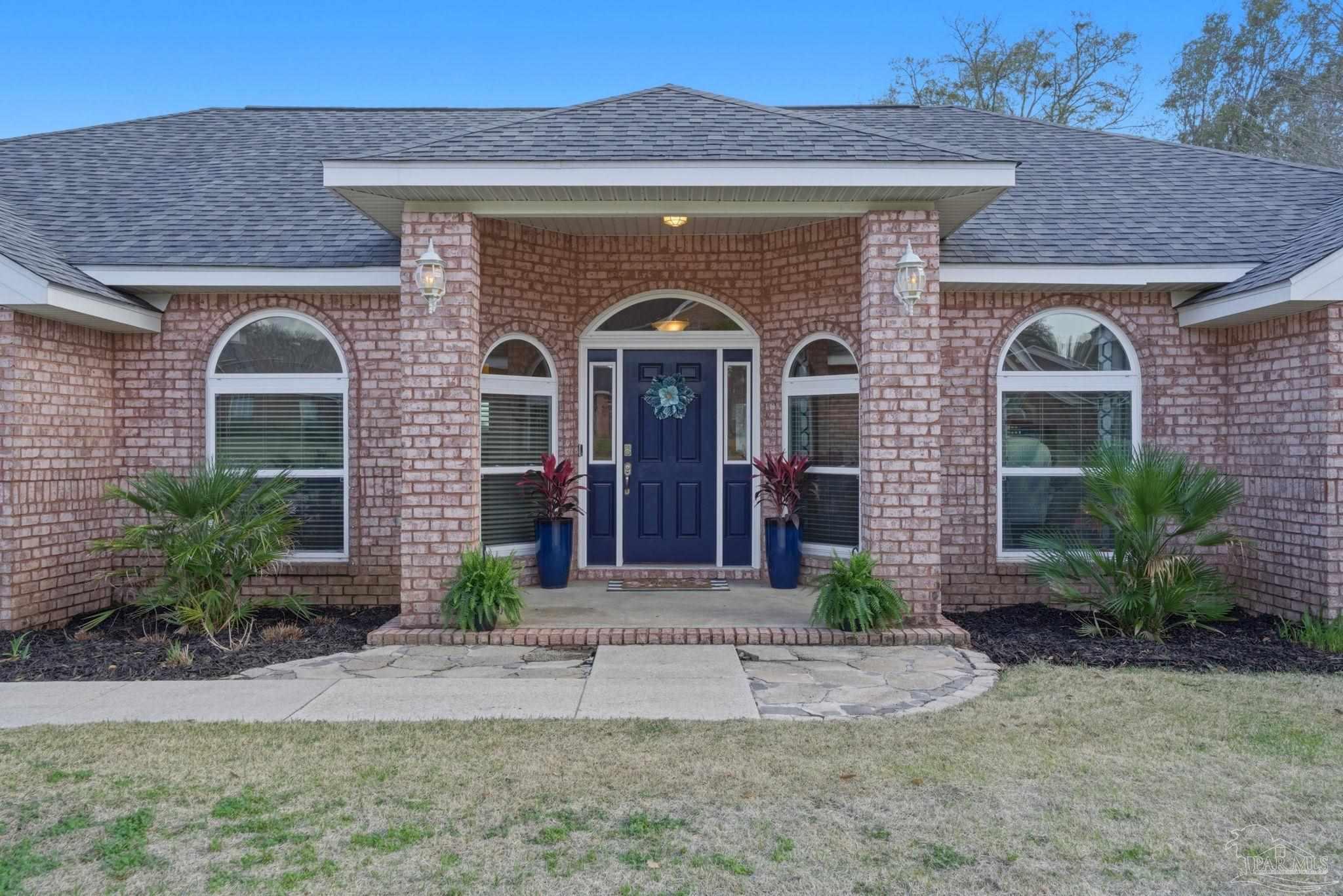 4249 Spindlewick Drive Pace, FL 32571 - Photo 4 of 26 a front view of a house with garden