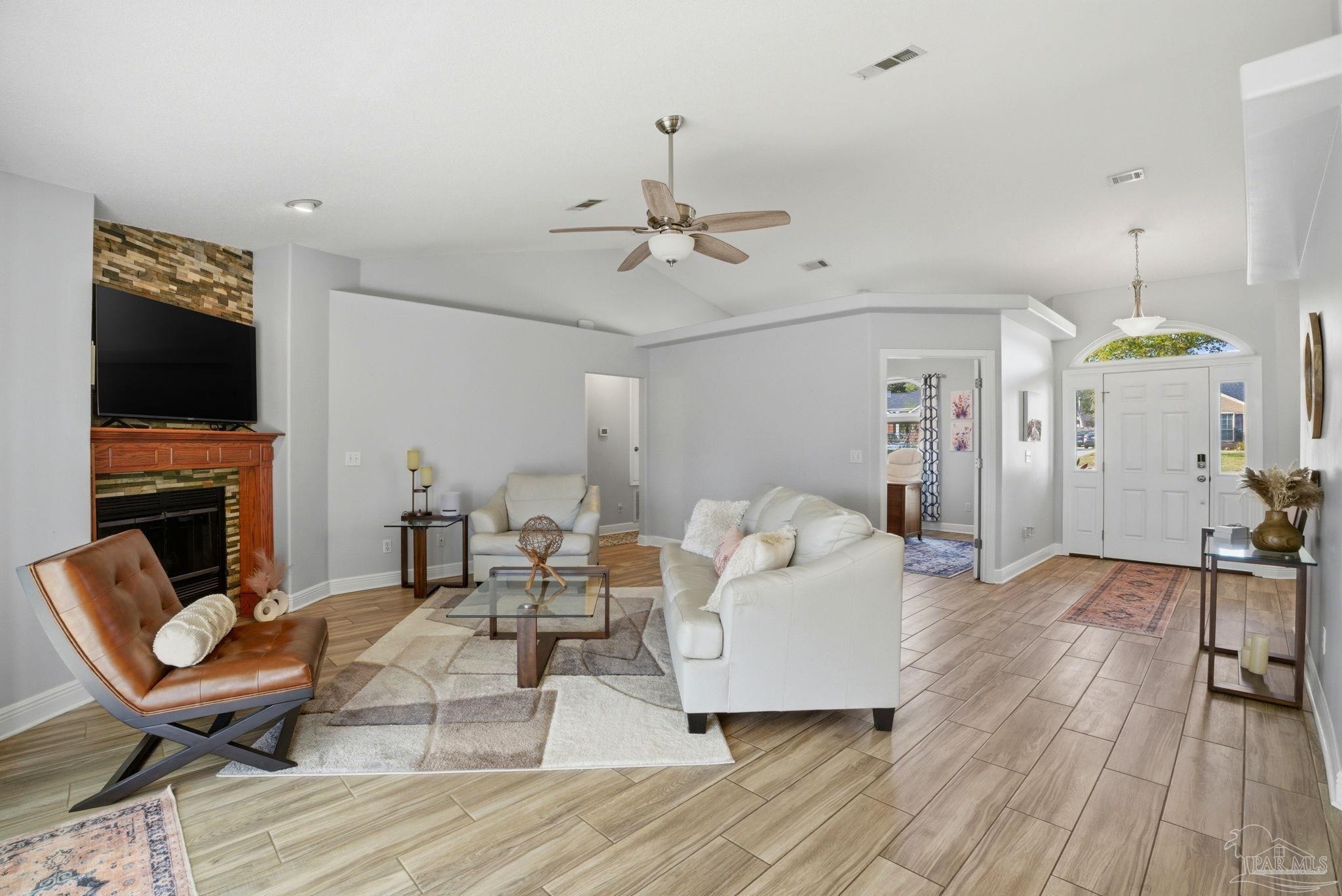 4249 Spindlewick Drive Pace, FL 32571 - Photo 5 of 26 a living room with furniture a flat screen tv and a fireplace