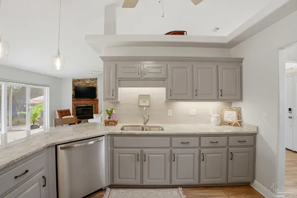 a kitchen with granite countertop a sink stainless steel appliances and cabinets