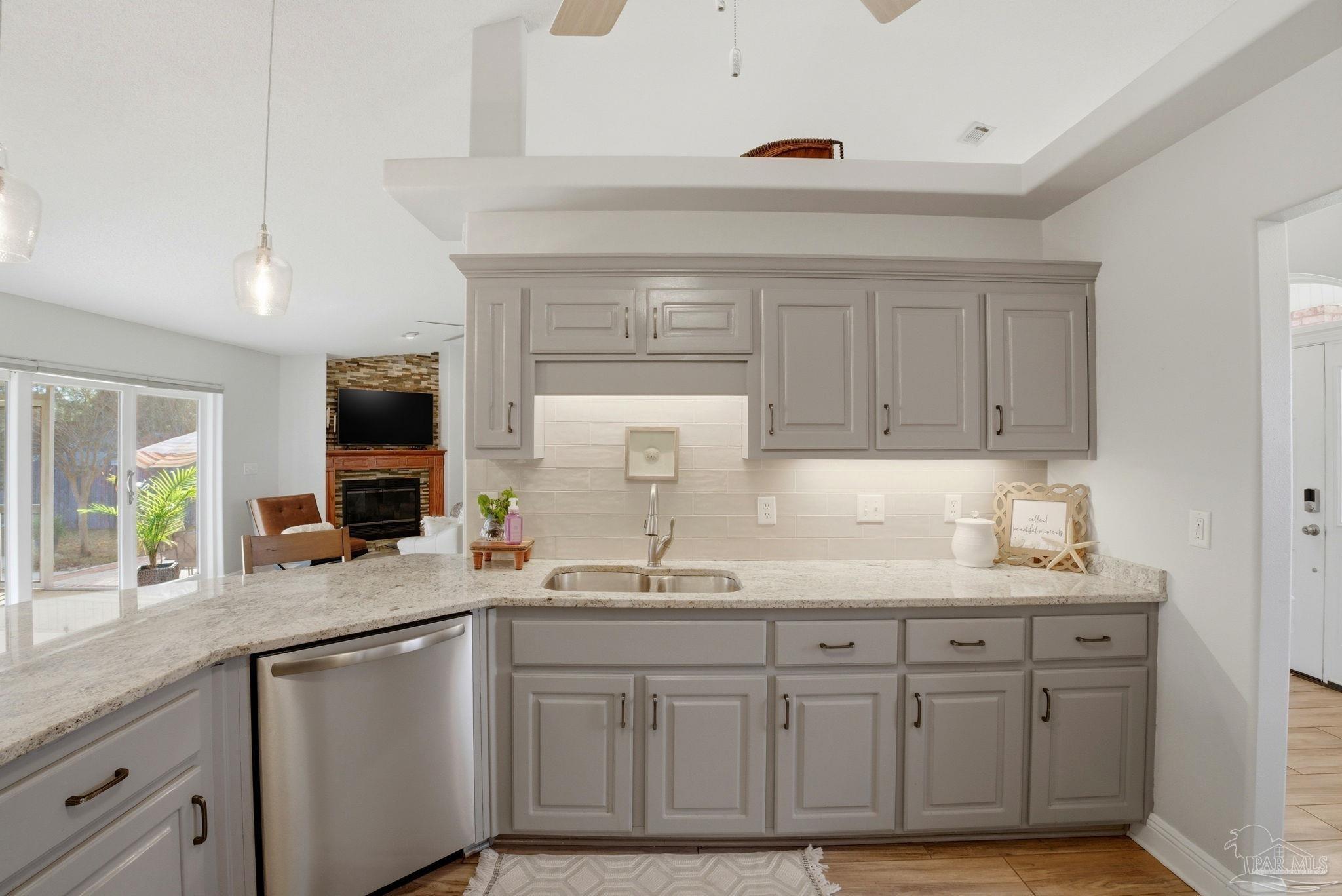 4249 Spindlewick Drive Pace, FL 32571 - Photo 9 of 26 a kitchen with granite countertop a sink stainless steel appliances and cabinets