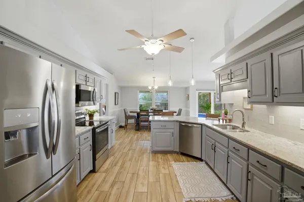 a kitchen with counter top space a sink appliances and cabinets