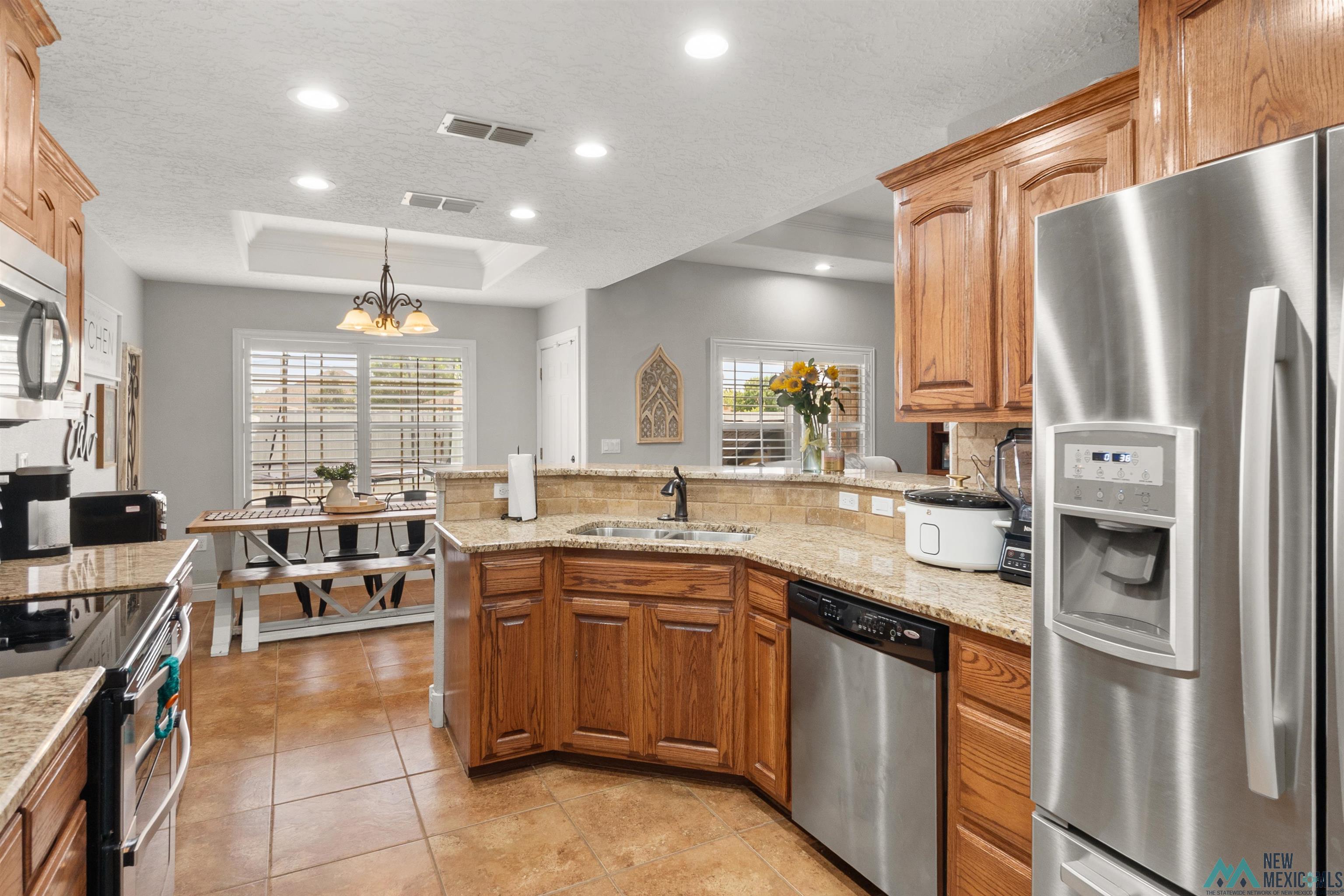 3913 Woodlark Road Clovis, NM 88101 - Photo 12 of 28 Open-concept kitchen with wood cabinetry and granite countertops
