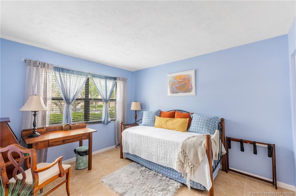 3171 Southeast Aster Lane, Unit 1103 Stuart, FL 34994 - Photo 13 of 26 a bedroom with a bed and a large window