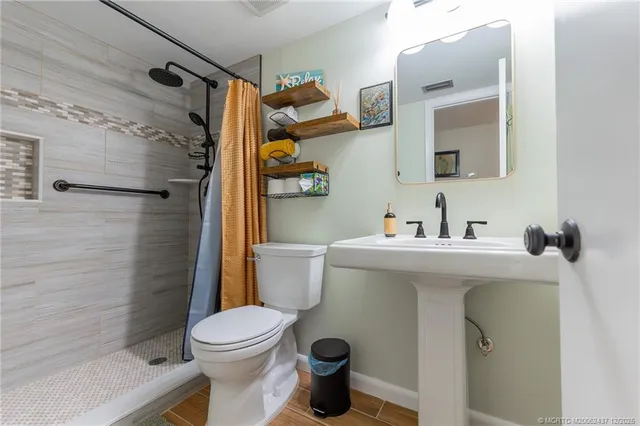 a bathroom with a sink a toilet and shower