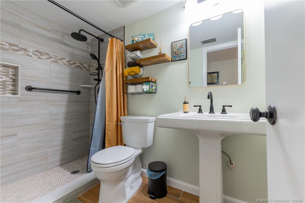 3171 Southeast Aster Lane, Unit 1103 Stuart, FL 34994 - Photo 15 of 26 a bathroom with a sink a toilet and shower