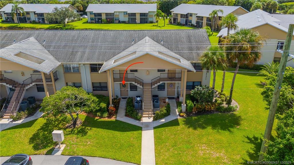 3171 Southeast Aster Lane, Unit 1103 Stuart, FL 34994 - Photo 19 of 26 a aerial view of a house with a yard table and chairs