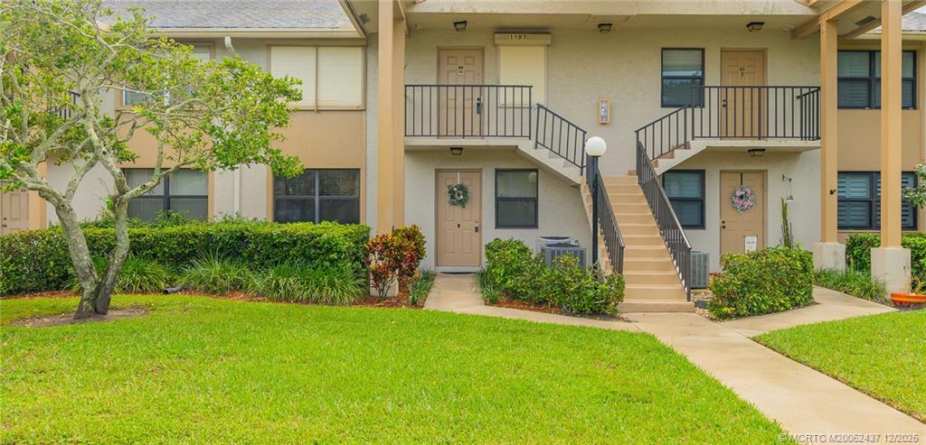 3171 Southeast Aster Lane, Unit 1103 Stuart, FL 34994 - Photo 2 of 26 a front view of a house with garden