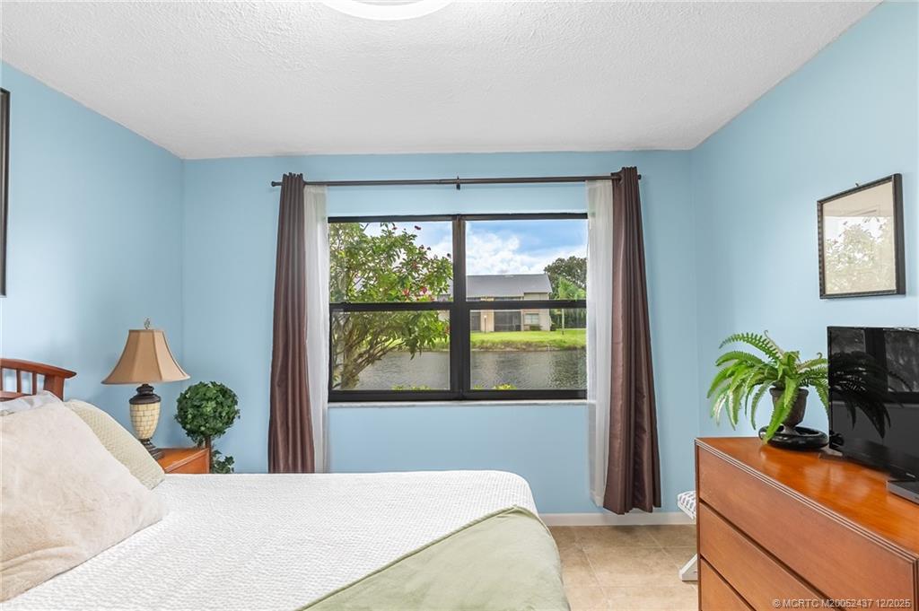 3171 Southeast Aster Lane, Unit 1103 Stuart, FL 34994 - Photo 10 of 26 a bedroom with a bed and a window