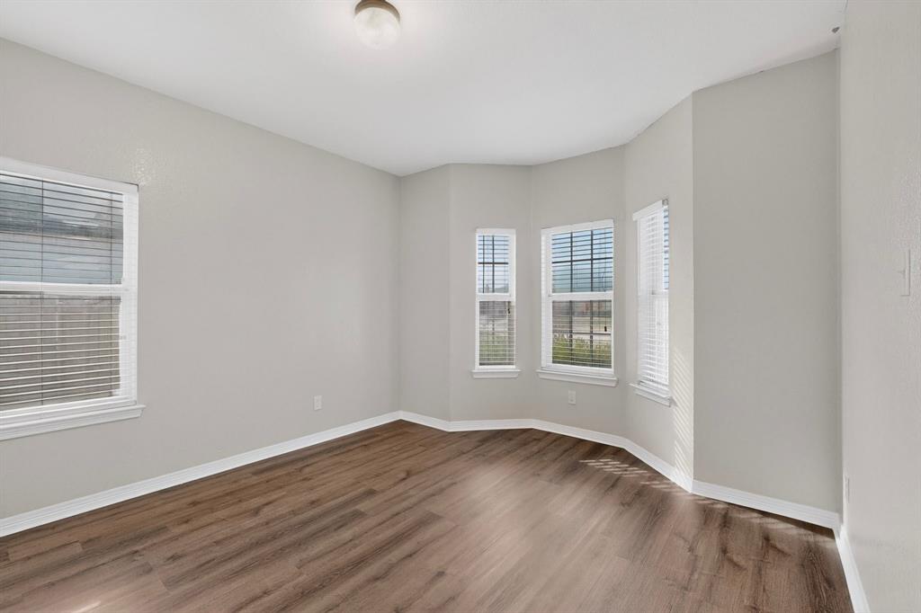 3401 Newgate Street Midlothian, TX 76065 - Photo 5 of 34 Room featuring wood-finish flooring, light gray walls, white baseboards, and multiple windows with blinds
