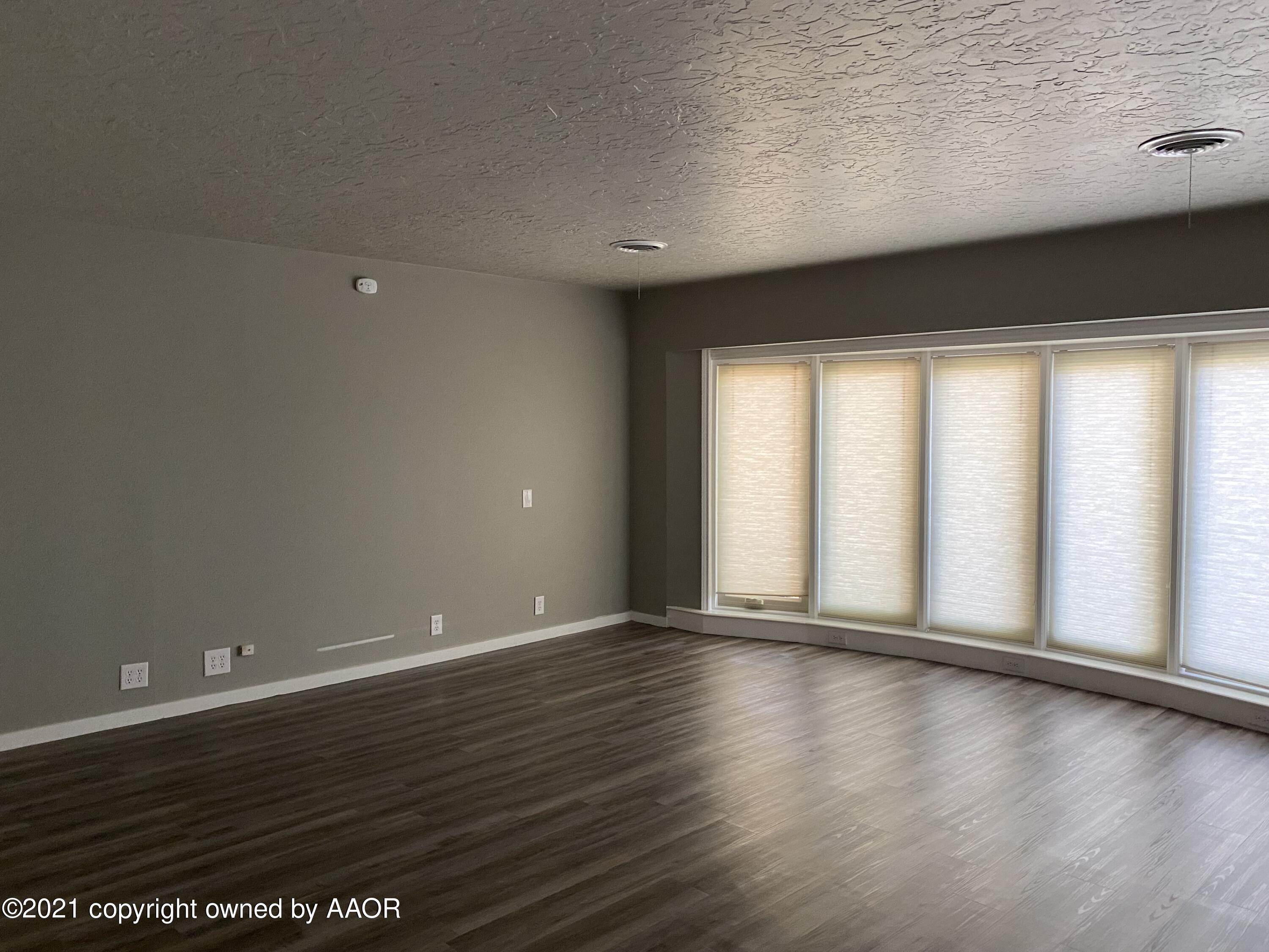 7111 Imperial Trail Amarillo, TX 79106 - Photo 2 of 13 a view of an empty room with wooden floor and a window