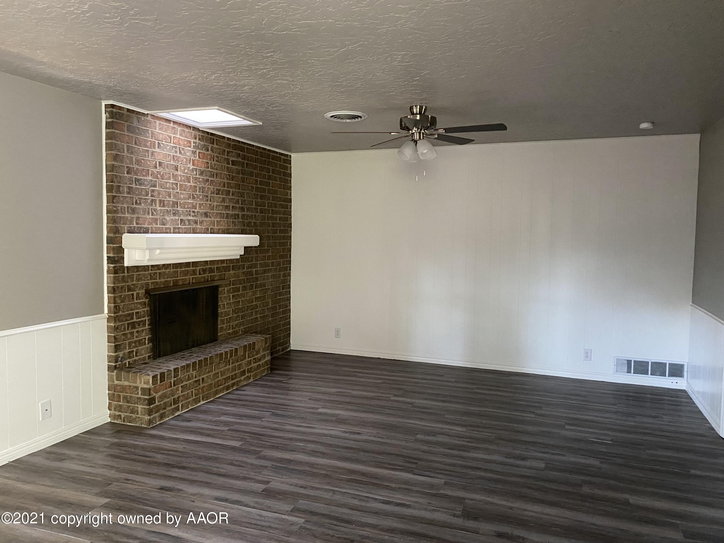 7111 Imperial Trail Amarillo, TX 79106 - Photo 3 of 13 a view of an empty room with wooden floor and a fireplace