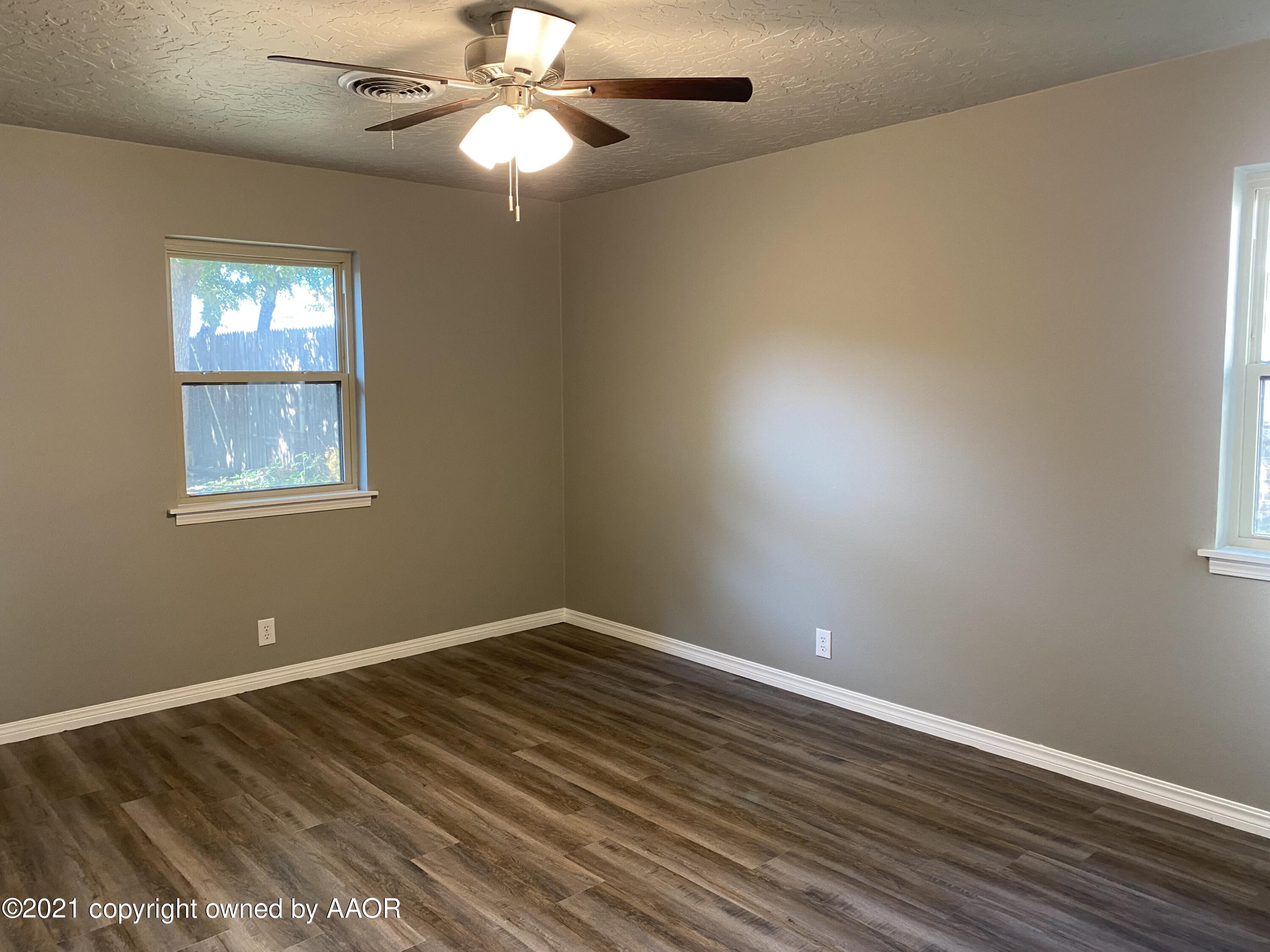 7111 Imperial Trail Amarillo, TX 79106 - Photo 6 of 13 a view of an empty room with wooden floor and a window