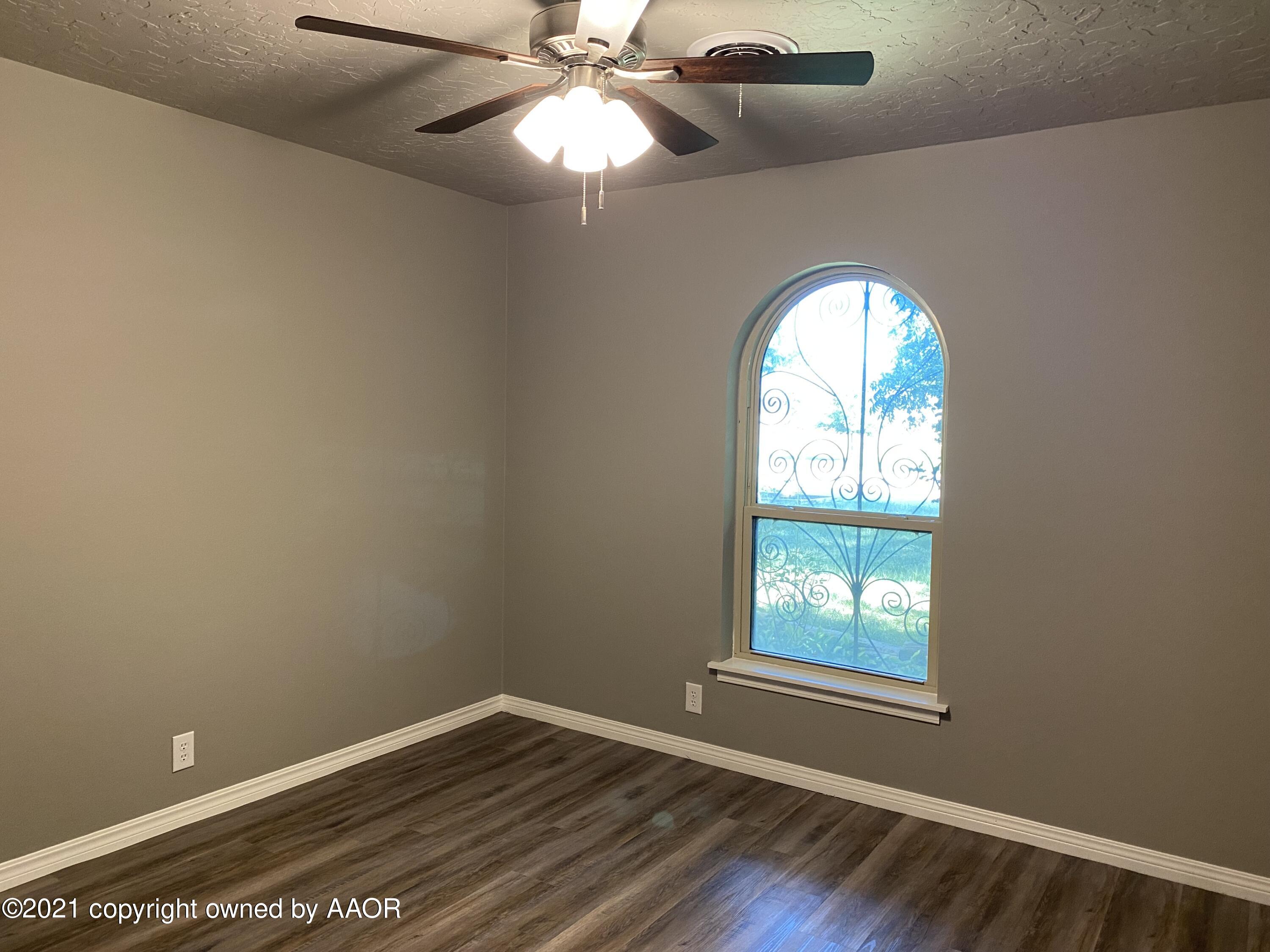 7111 Imperial Trail Amarillo, TX 79106 - Photo 9 of 13 an empty room with windows and chandelier fan