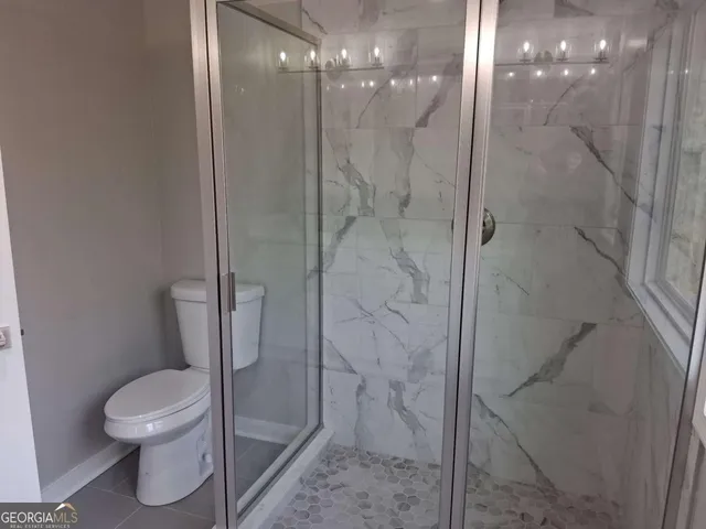 a bathroom with a toilet and a shower