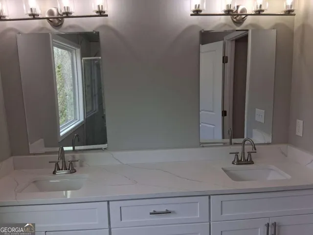 a bathroom with a sink and two mirror