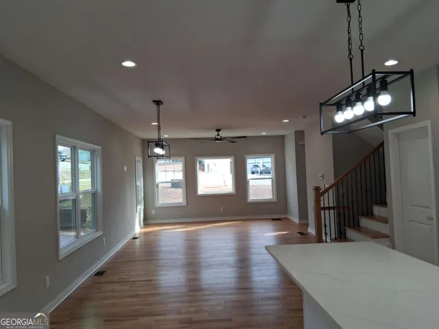 a hallway with wooden floor chandelier and entryway