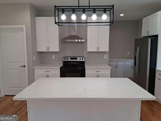 a kitchen with stainless steel appliances a refrigerator a stove a microwave and cabinets