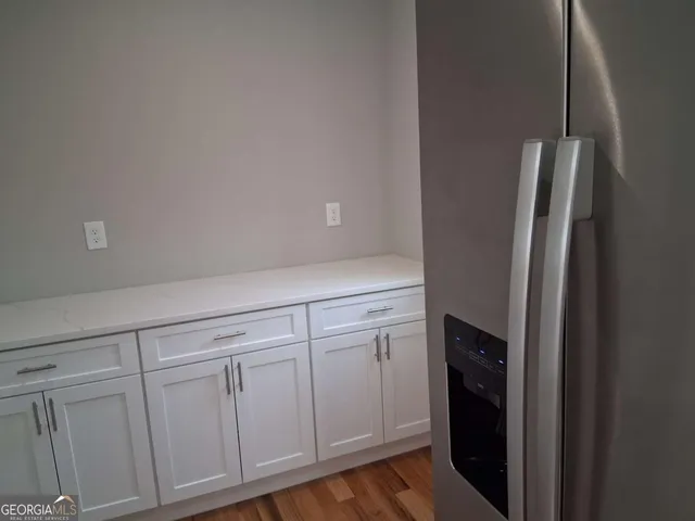 a kitchen with white cabinets and refrigerator