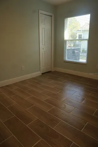 an empty room with wooden floor and a ceiling fan