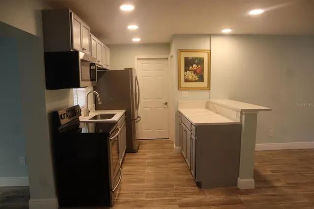 a kitchen with wooden cabinets and stainless steel appliances