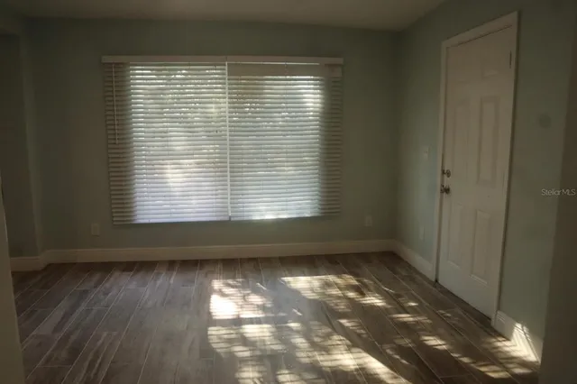 a view of a room with wooden floor and a window