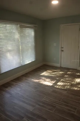 a view of an empty room with a chandelier fan
