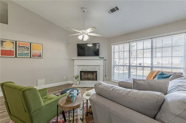 a living room with furniture a flat screen tv and a fireplace