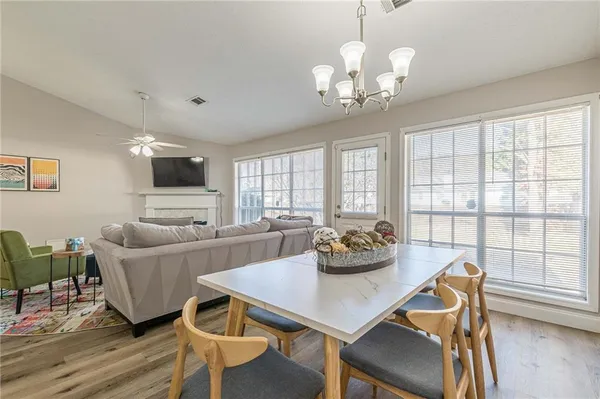 a living room with furniture a chandelier and a dining table