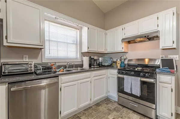 a kitchen with white cabinets and appliances