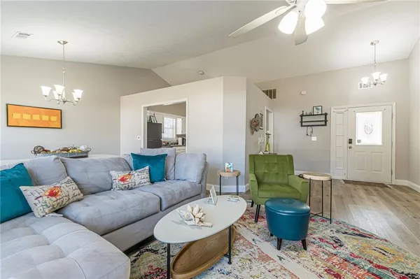 a living room with furniture a lamp and wooden floor