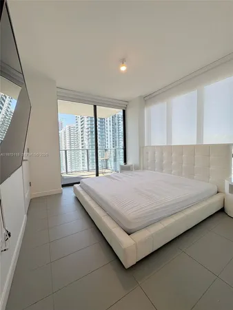 a bedroom with a bed and a large window