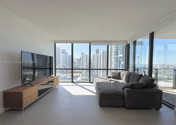 a living room with furniture and a floor to ceiling window