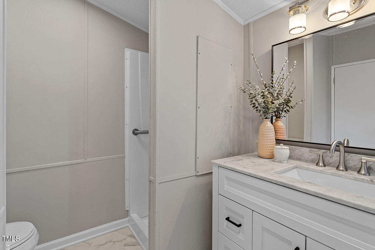858 Foster Road Henderson, NC 27537 - Photo 29 of 38 a bathroom with a granite countertop sink toilet and shower