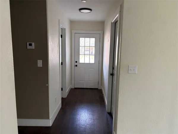 a view of a hallway with wooden floor