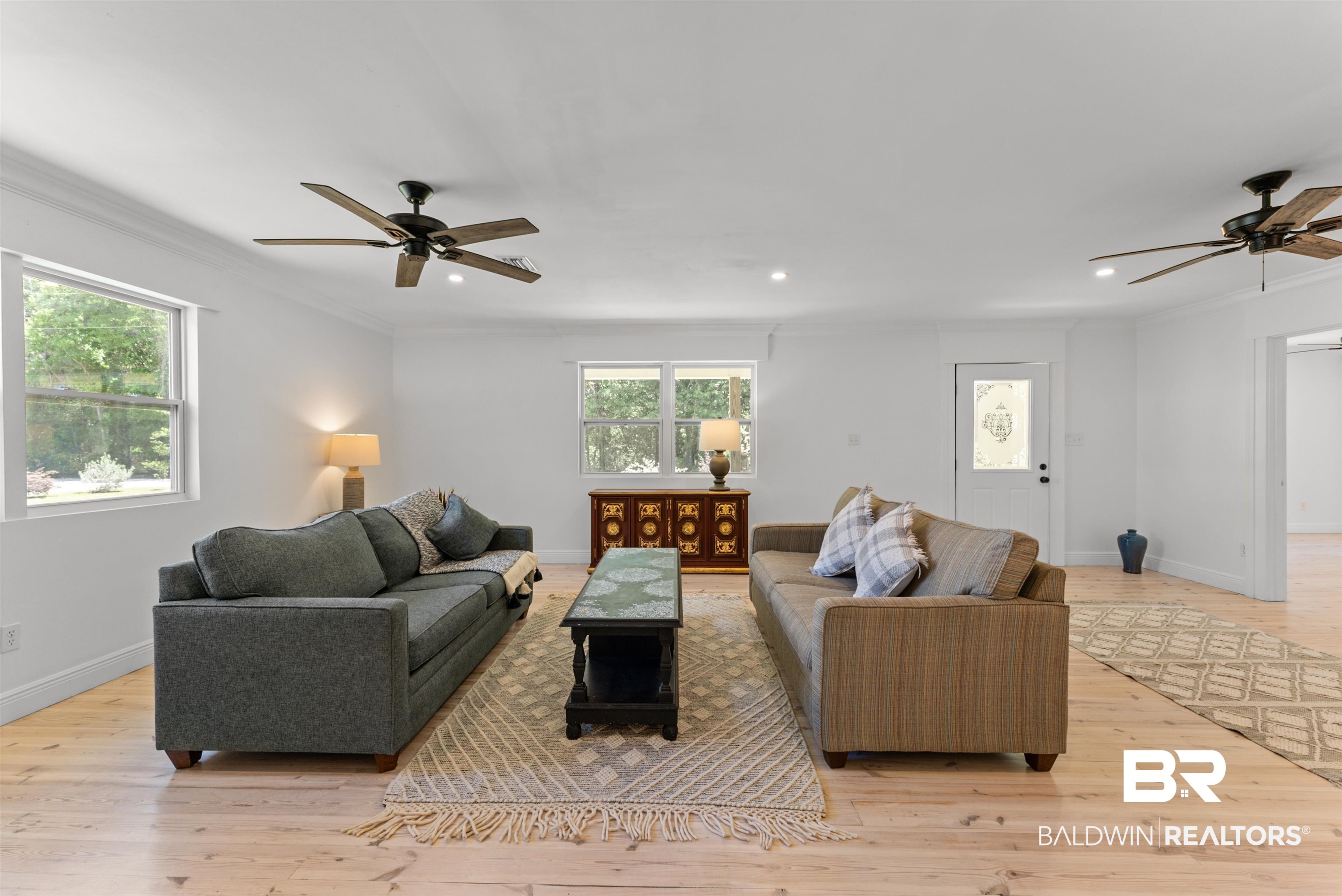 6447 Bemis Lane Bon Secour, AL 36511 - Photo 19 of 62 Spacious living area featuring light wood-finish flooring, white walls, and crown molding
