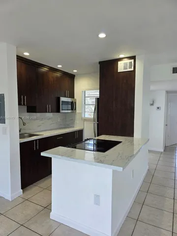 a kitchen with stainless steel appliances granite countertop a refrigerator and a stove
