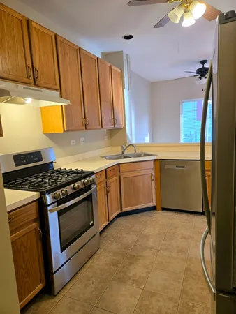 a kitchen with stainless steel appliances granite countertop a stove a sink and a refrigerator