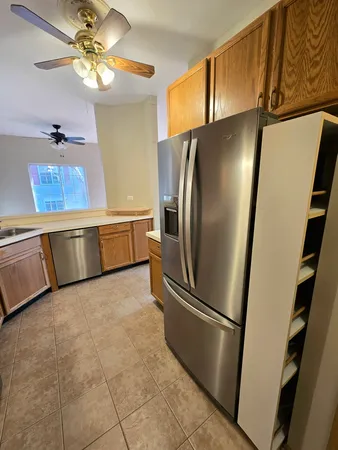 a kitchen with stainless steel appliances granite countertop a refrigerator a oven and a sink with granite countertops