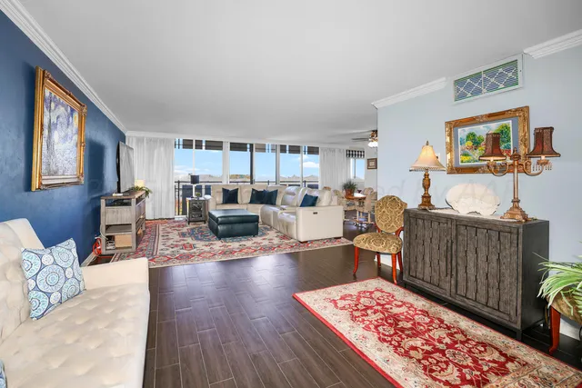a living room with furniture a flat screen tv and a floor to ceiling window