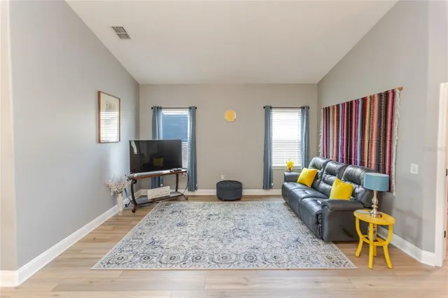 a living room with furniture a rug and a mirror