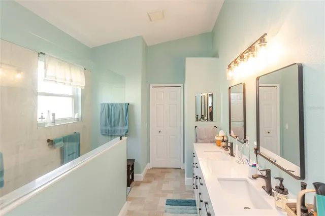 a backyard of a house with wooden fence and a large tree